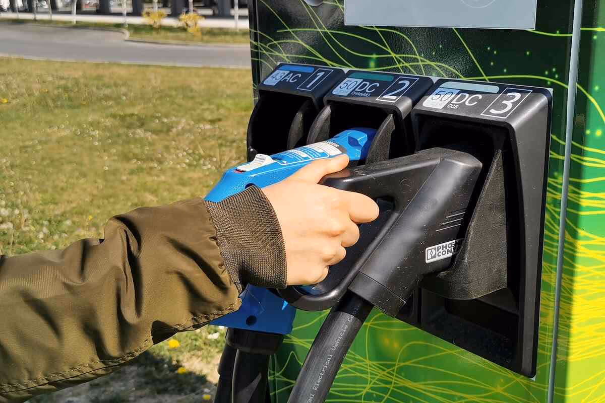 hand holding electric vehicle charger