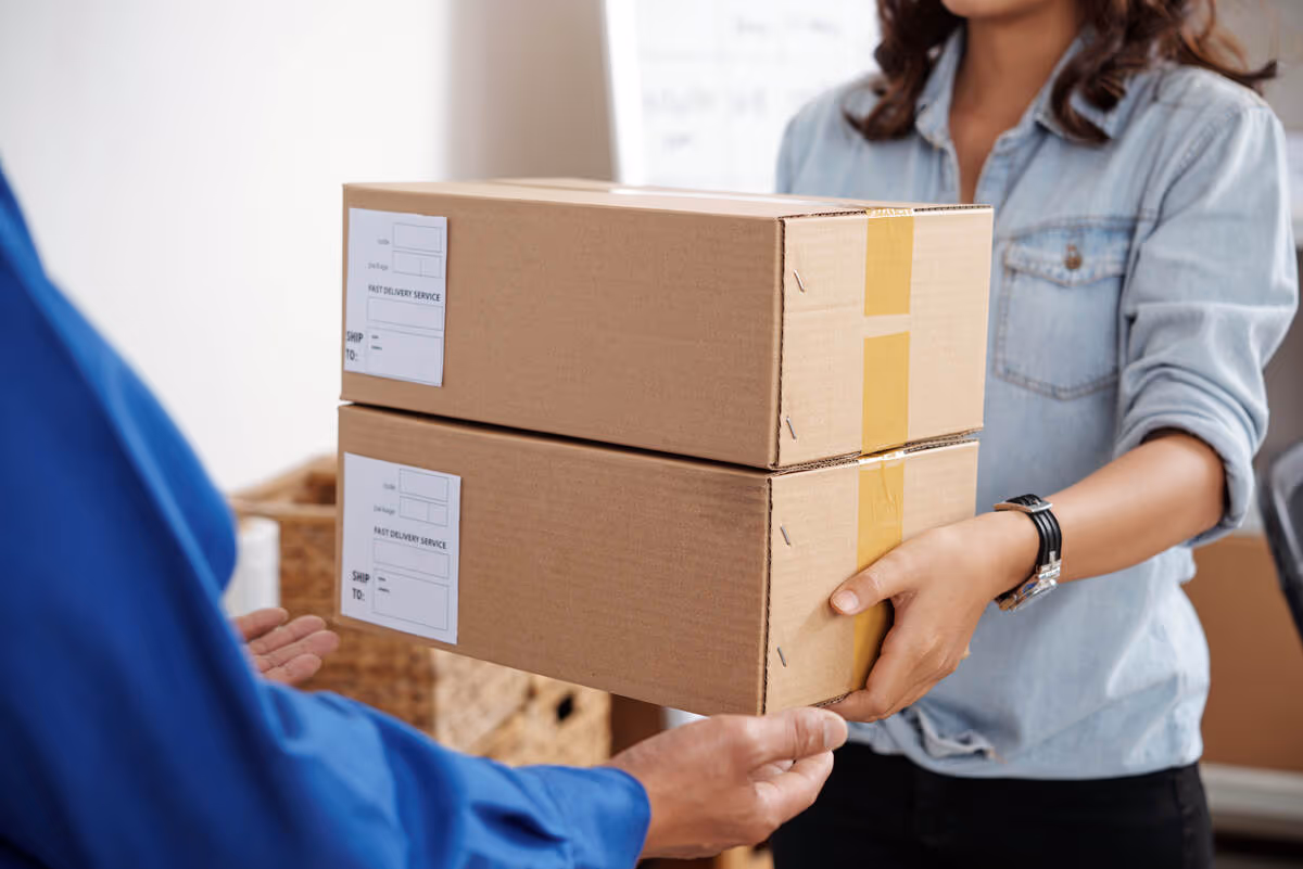 young postwoman giving package to the man at the post office