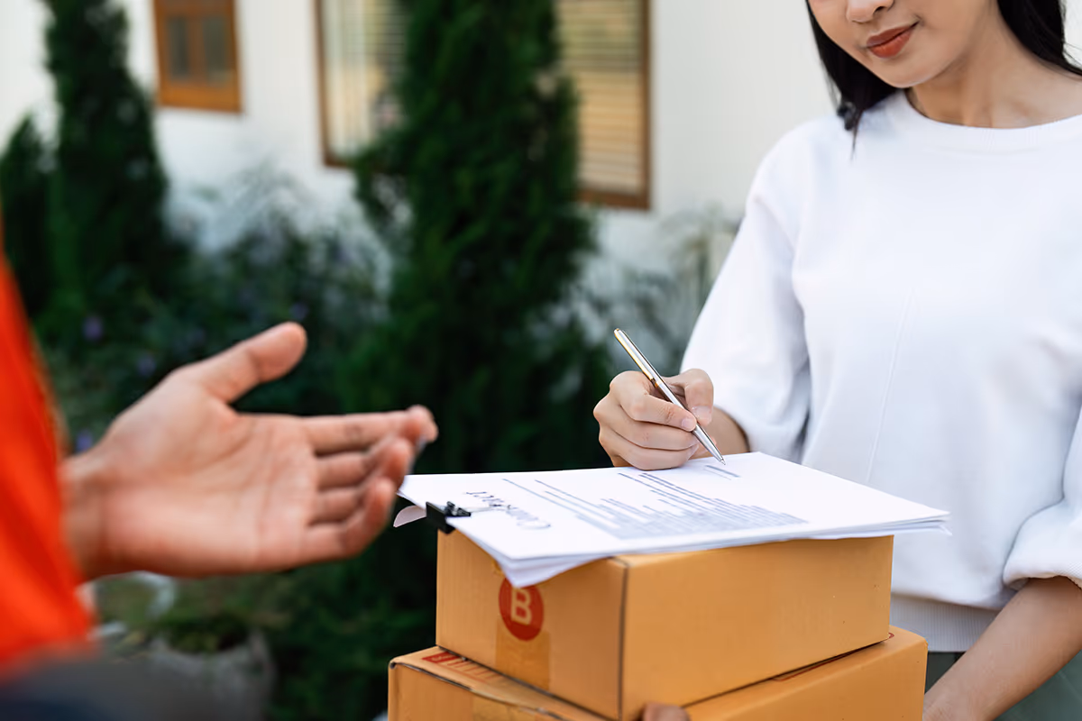 Girl holding and signing for a package.